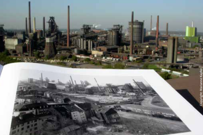 Industrie in Farbe fotografiert und im Vordergrund als Schwarz-Weiß-Foto in einem Buch