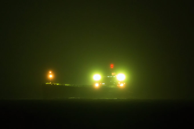 Bergung der „Glory Amsterdam“: Im Scheinwerferlicht lassen sich die beiden am Heck befestigten Schleppleinen (rechts) erahnen, mit denen der Frachter von der Sandbank gezogen werden konnte. - Foto: NABU/Klemens Karkow 